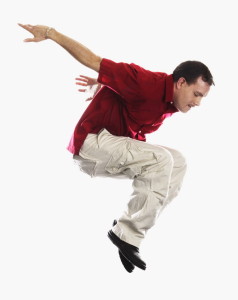 Young Man in Casual Attire Jumping Expressively into Air